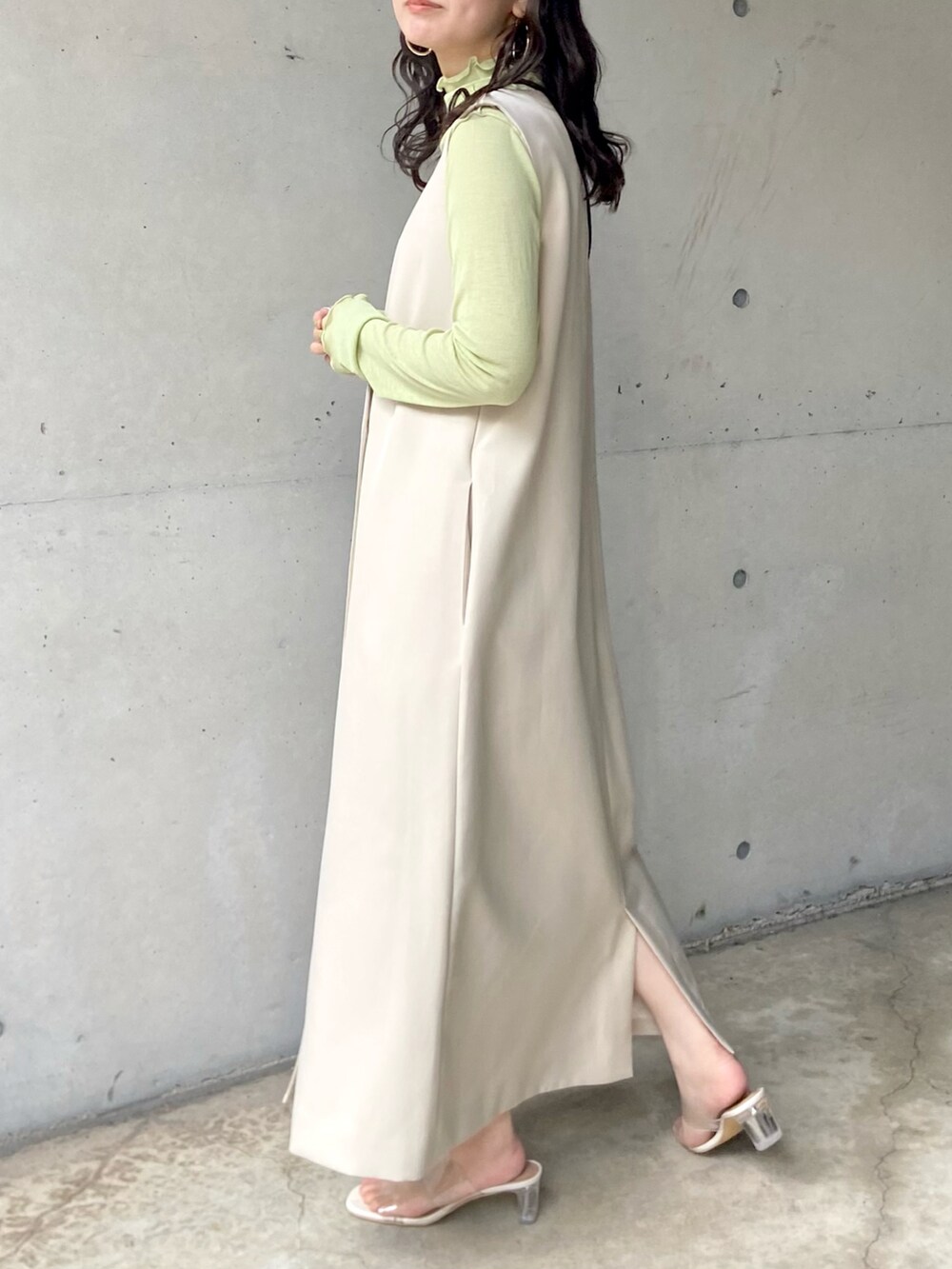 ホワイト系のサンダル、ホワイト系のジャンパースカート、グリーン系のTシャツ/カットソーを着用したレディースの春コーディネートの2枚目の写真