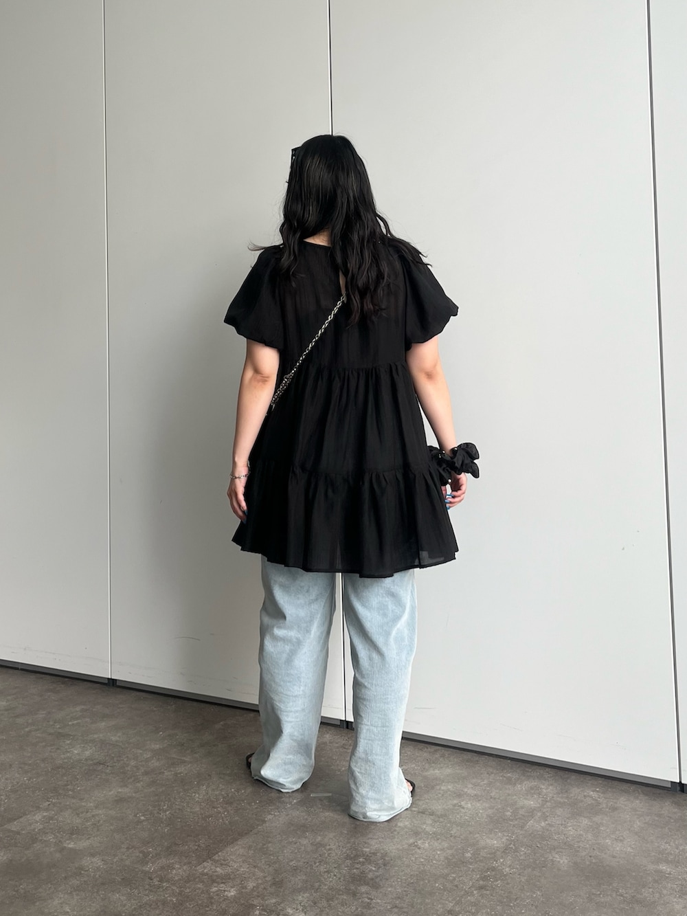 ブラック系のショルダーバッグ、ブルー系のデニムパンツ、ブラック系のシャツ/ブラウスを着用したレディースの夏コーディネートの3枚目の写真