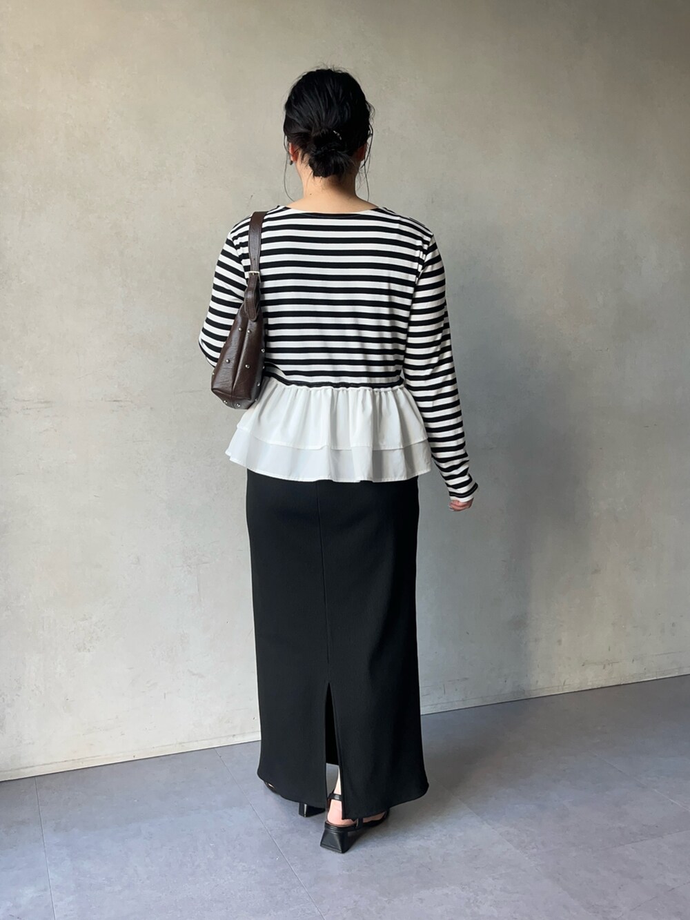 ブラック系のTシャツ/カットソー、ブラック系のスカート、ブラック系のサンダルを着用したレディースの春コーディネートの3枚目の写真