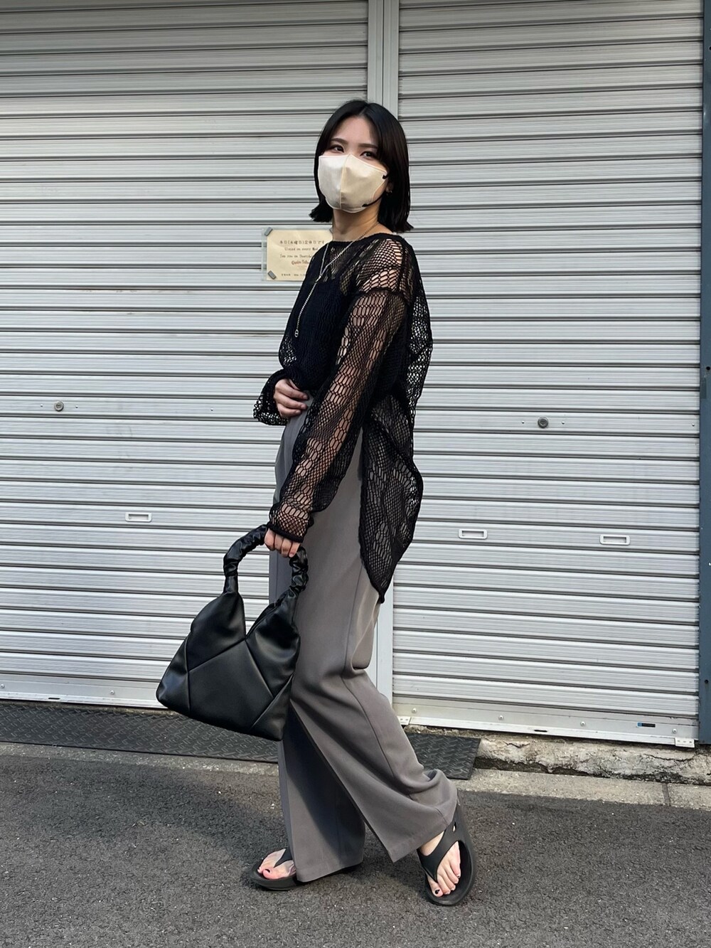 ブラック系のキャミソール、グレー系のスラックス、ブラック系のニット/セーターを着用したレディースの春コーディネートの2枚目の写真