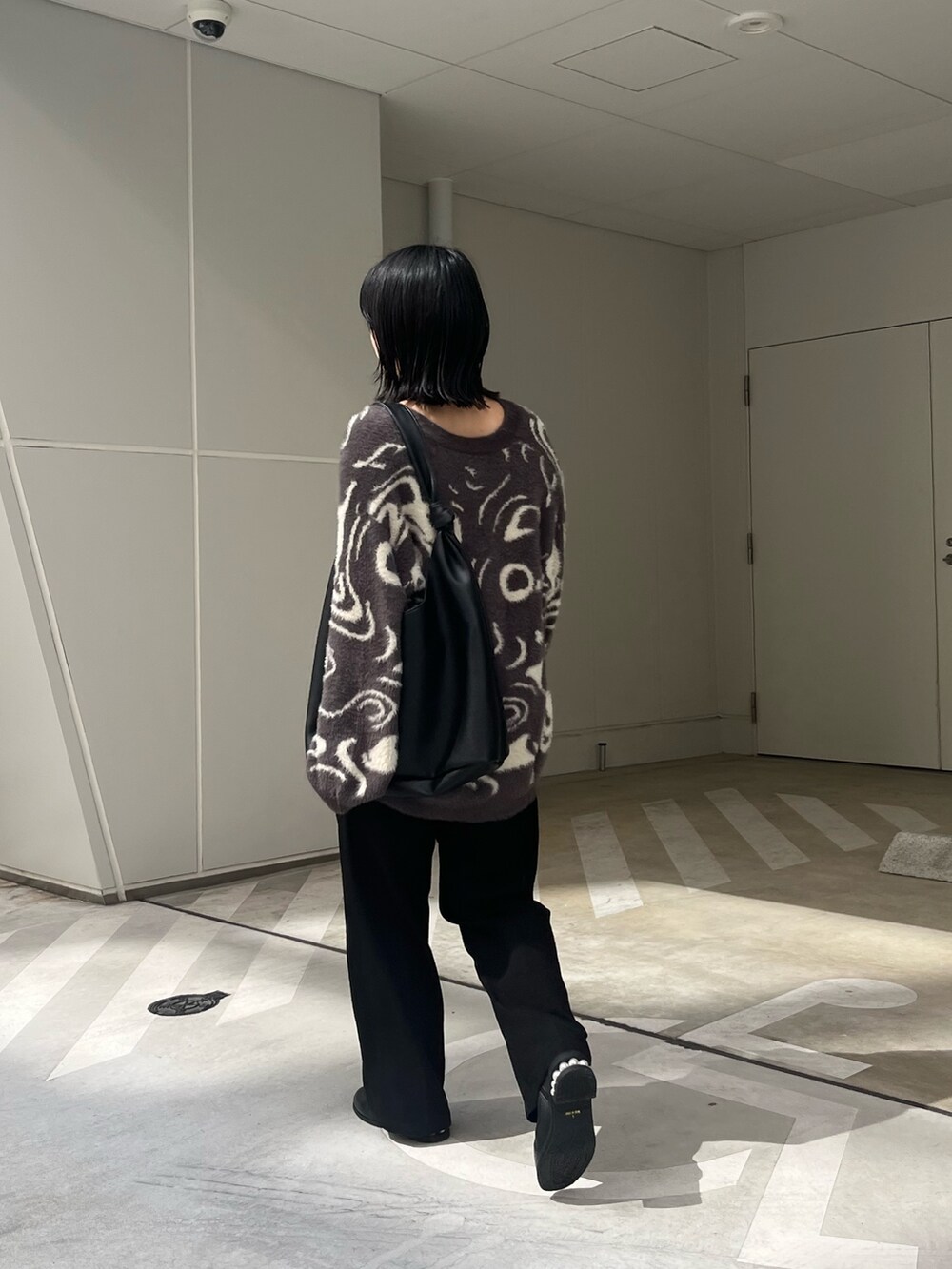 グレー系のカーディガン/ボレロ、ブラック系のトートバッグ、ブラック系のスラックスを着用したレディースの秋コーディネートの3枚目の写真