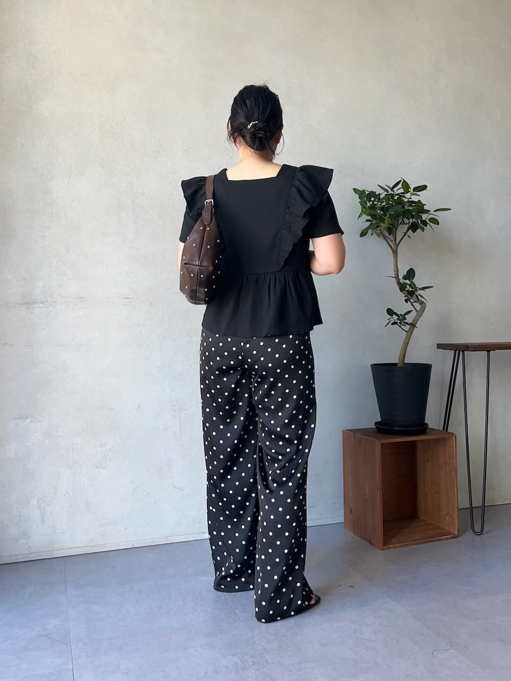 ブラック系のその他パンツ、ブラウン系のショルダーバッグ、ブラック系のシャツ/ブラウスを着用したレディースの春コーディネートの3枚目の写真