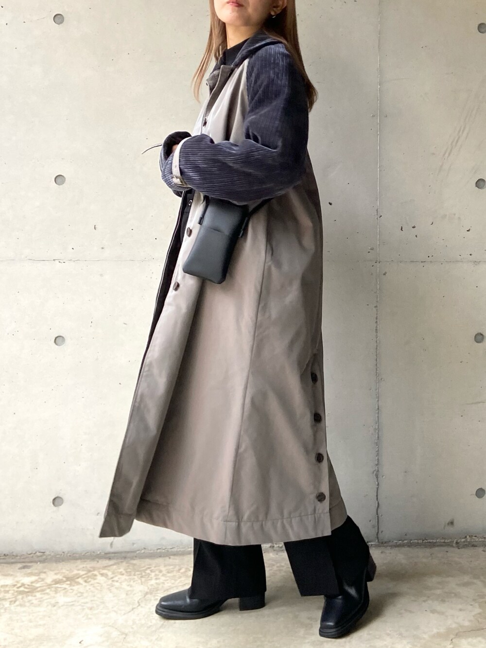 グレー系のステンカラーコート、ブラック系のショルダーバッグ、ブラック系のニット/セーターを着用したレディースの秋コーディネートの4枚目の写真