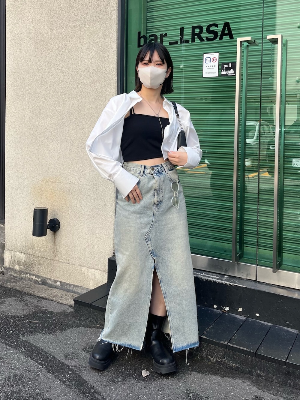 ブラック系のブーツ、ホワイト系のシャツ/ブラウス、ブラック系のキャミソールを着用したレディースの春コーディネートの2枚目の写真