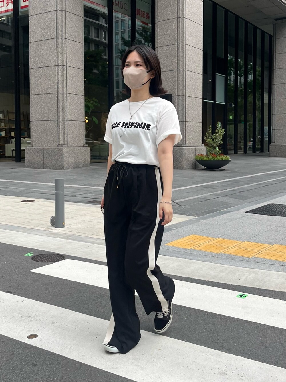 ブラック系のその他パンツ、ホワイト系のTシャツ/カットソー、シルバー系のネックレスを着用したレディースの夏コーディネートの2枚目の写真