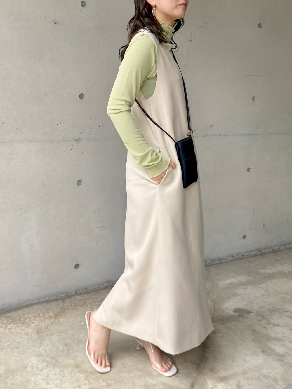 ホワイト系のサンダル、ホワイト系のジャンパースカート、グリーン系のTシャツ/カットソーを着用したレディースの春コーディネートの3枚目の写真