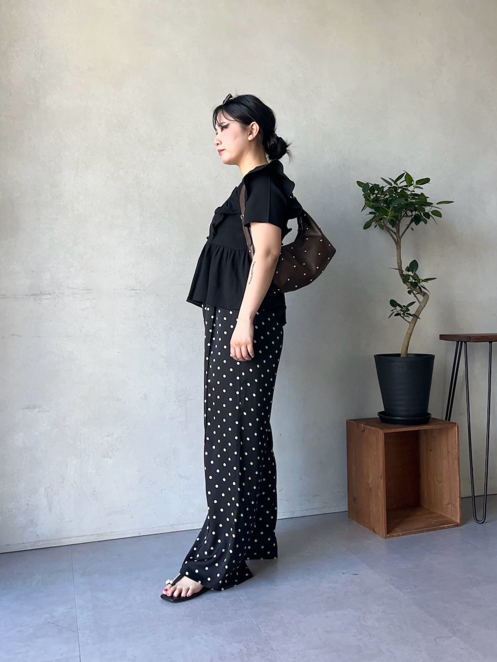 ブラック系のその他パンツ、ブラウン系のショルダーバッグ、ブラック系のシャツ/ブラウスを着用したレディースの春コーディネートの2枚目の写真