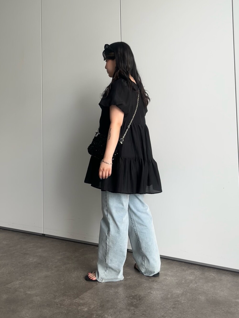 ブラック系のショルダーバッグ、ブルー系のデニムパンツ、ブラック系のシャツ/ブラウスを着用したレディースの夏コーディネートの2枚目の写真