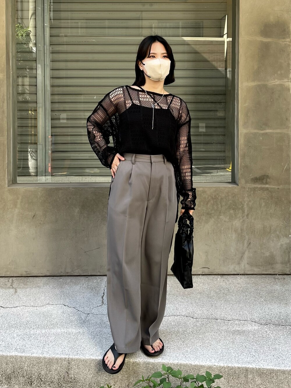 ブラック系のキャミソール、グレー系のスラックス、ブラック系のニット/セーターを着用したレディースの春コーディネートの3枚目の写真