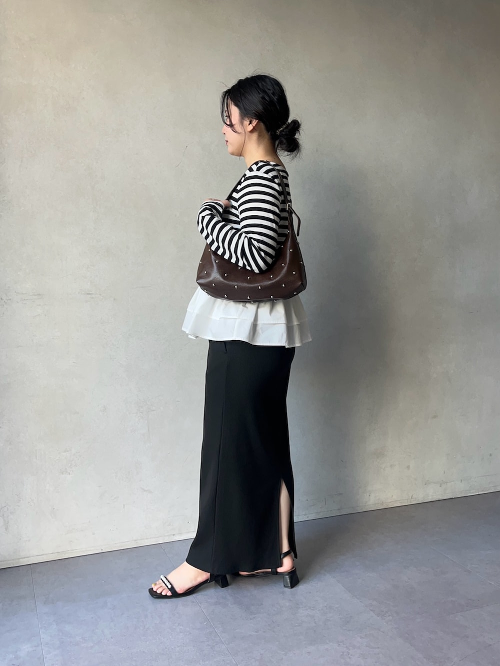 ブラック系のTシャツ/カットソー、ブラック系のスカート、ブラック系のサンダルを着用したレディースの春コーディネートの2枚目の写真