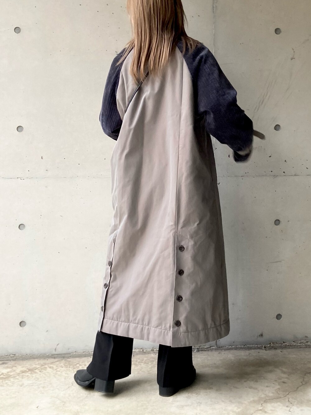 グレー系のステンカラーコート、ブラック系のショルダーバッグ、ブラック系のニット/セーターを着用したレディースの秋コーディネートの5枚目の写真