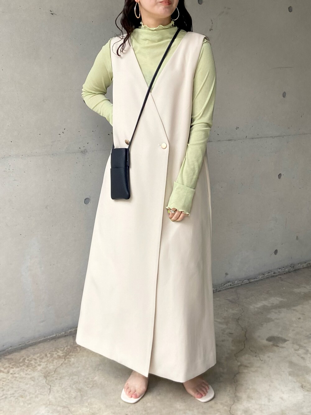 ホワイト系のサンダル、ホワイト系のジャンパースカート、グリーン系のTシャツ/カットソーを着用したレディースの春コーディネートの4枚目の写真