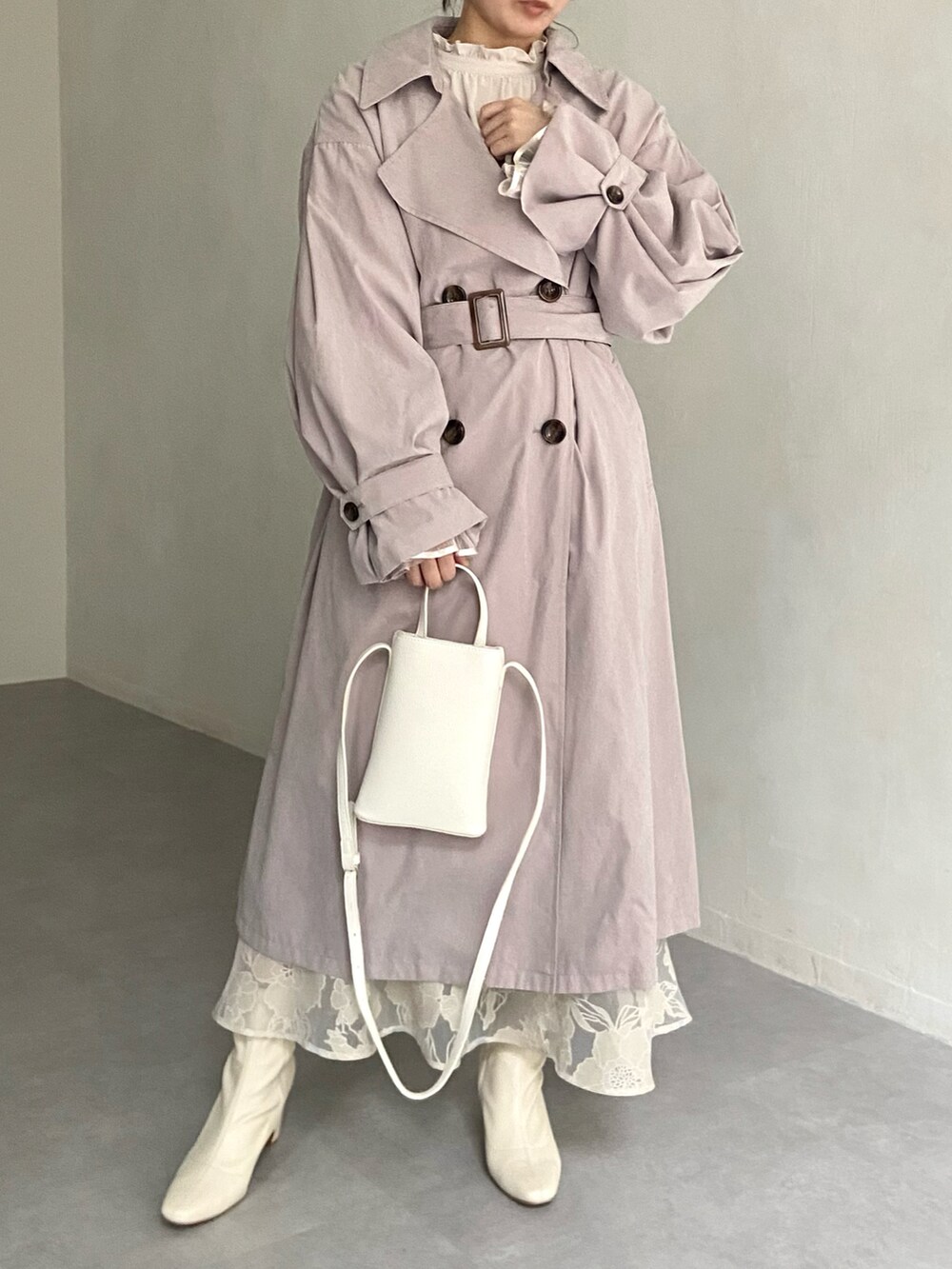 ホワイト系のショルダーバッグ、ベージュ系のトレンチコート、ベージュ系のシャツ/ブラウスを着用したレディースの冬コーディネートの2枚目の写真
