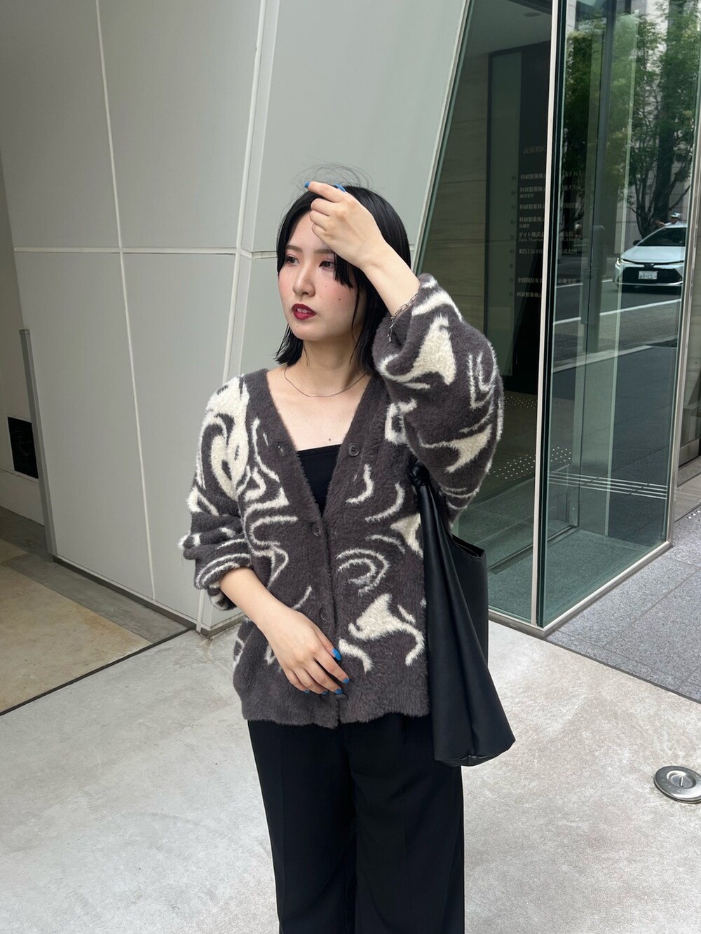 グレー系のカーディガン/ボレロ、ブラック系のトートバッグ、ブラック系のスラックスを着用したレディースの秋コーディネートの2枚目の写真