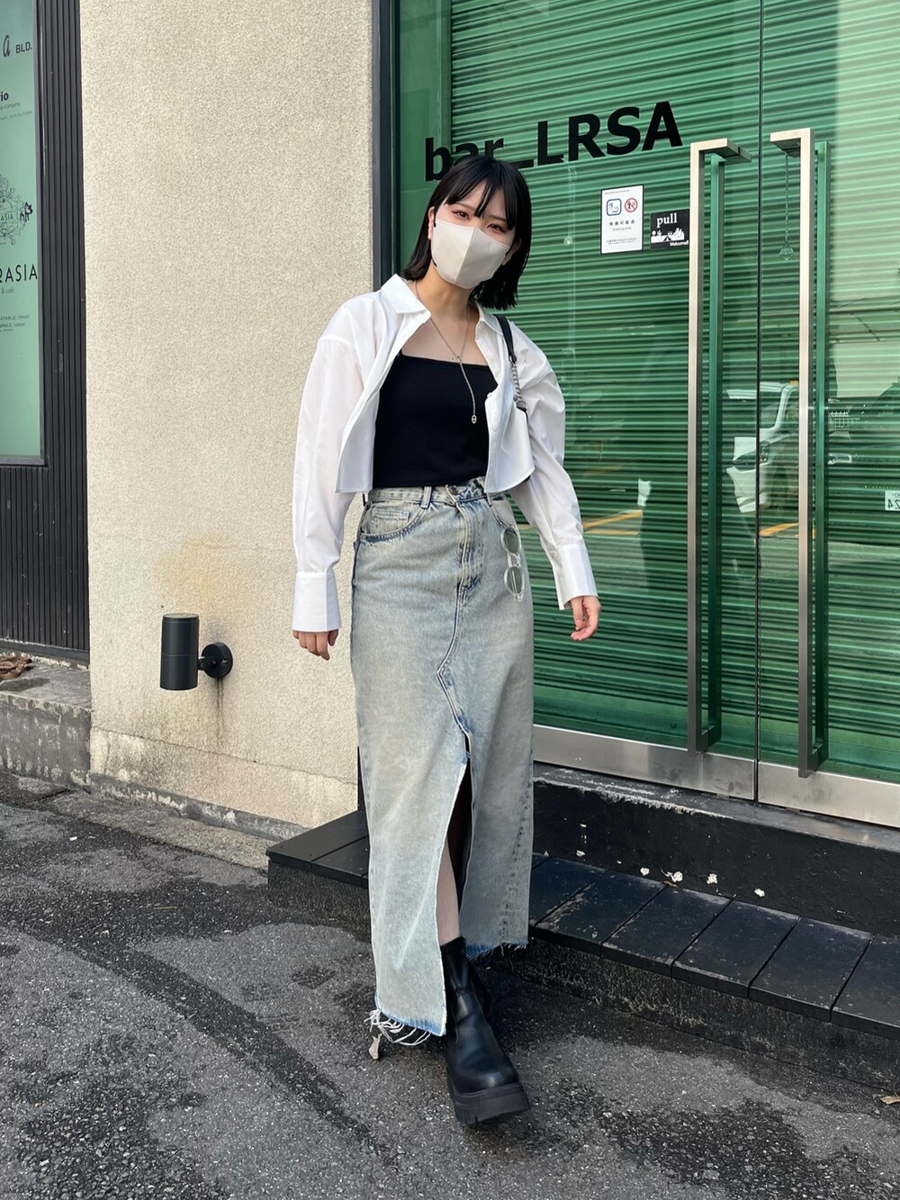 ブラック系のブーツ、ホワイト系のシャツ/ブラウス、ブラック系のキャミソールを着用したレディースの春コーディネートの3枚目の写真