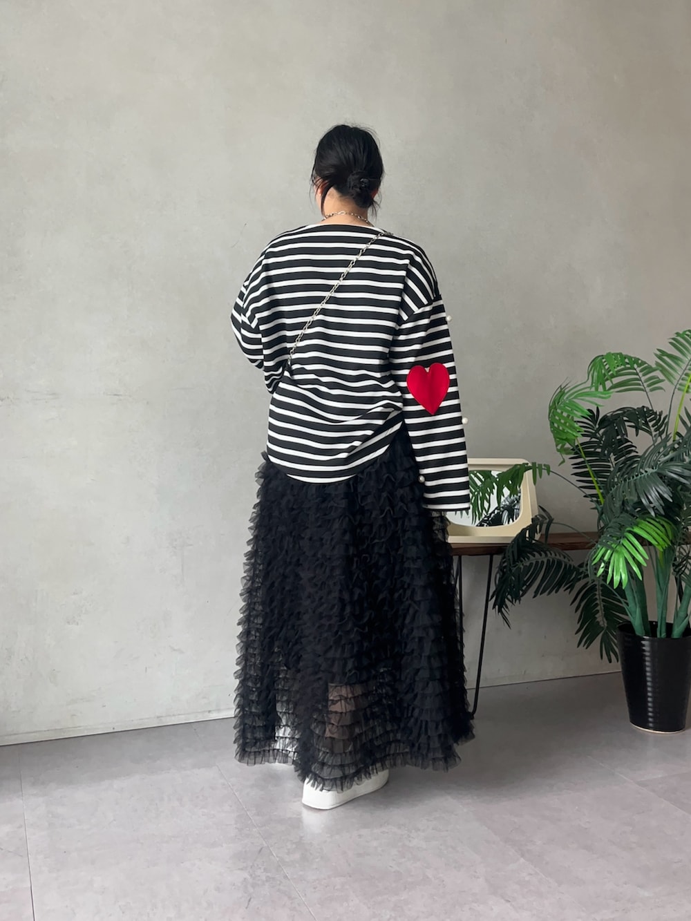 ホワイト系のスニーカー、ブラック系のTシャツ/カットソー、ブラック系のスカートを着用したレディースの夏コーディネートの2枚目の写真
