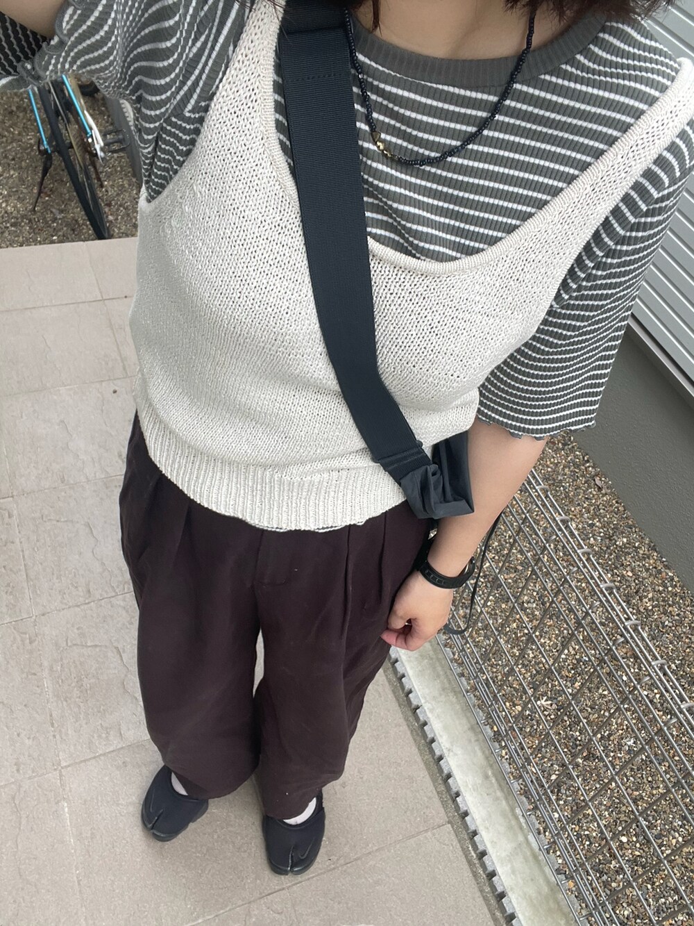 ブラック系のサンダルを着用したレディースの夏コーディネートの2枚目の写真