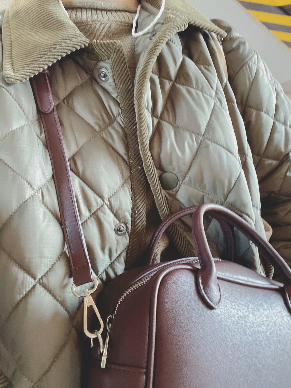 グリーン系のその他アウター、グリーン系のニット/セーター、ブルー系のデニムパンツを着用したレディースの秋コーディネートの2枚目の写真