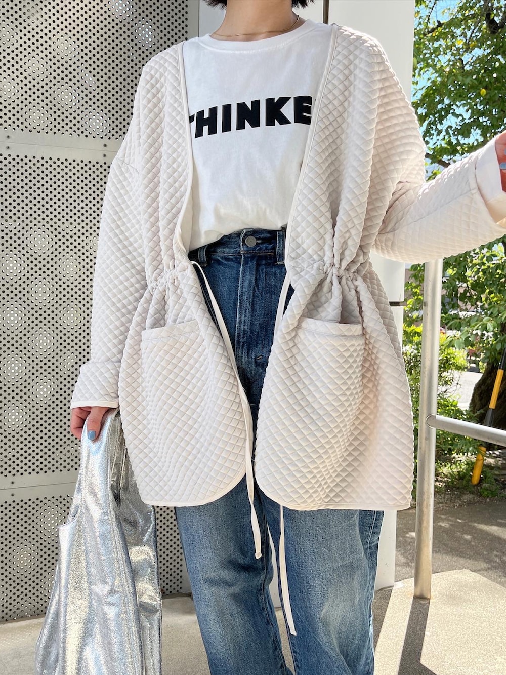 ホワイト系のノーカラージャケット、ベージュ系のスリッポン、ホワイト系のTシャツ/カットソーを着用したレディースの秋コーディネートの3枚目の写真