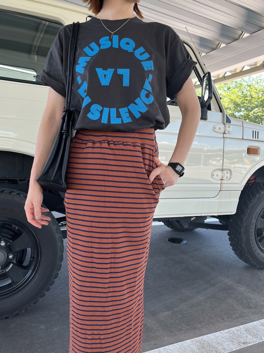 ブラック系のTシャツ/カットソー、ブラウン系のスカート、ブラック系のサンダルを着用したレディースの夏コーディネートの3枚目の写真