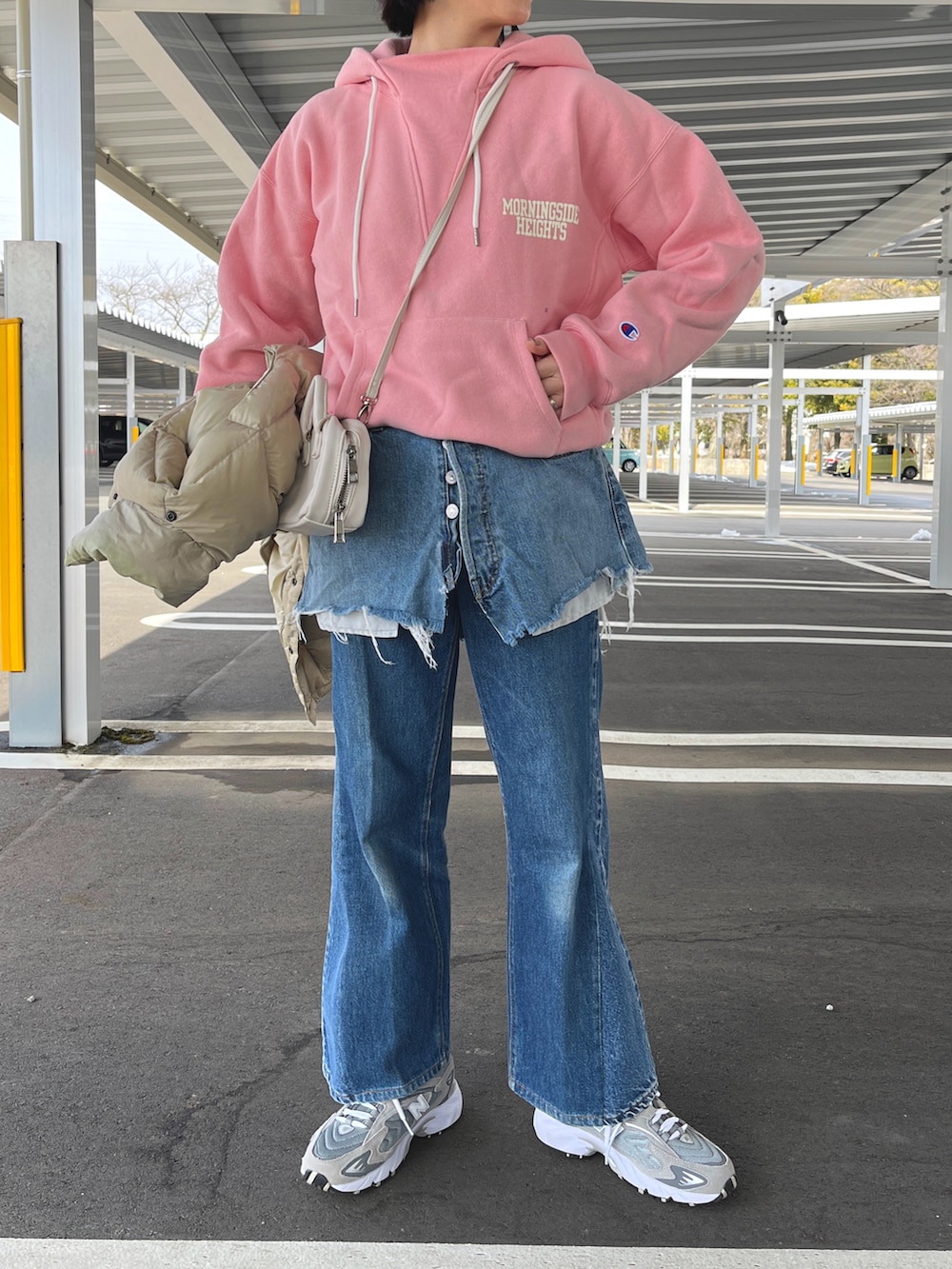 グレー系のスニーカー、ホワイト系のショルダーバッグを着用したレディースの春コーディネートの2枚目の写真