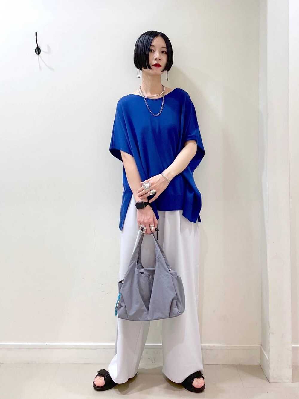 グレー系のその他パンツ、ブルー系のニット/セーター、グレー系のトートバッグを着用したレディースの夏コーディネートの2枚目の写真