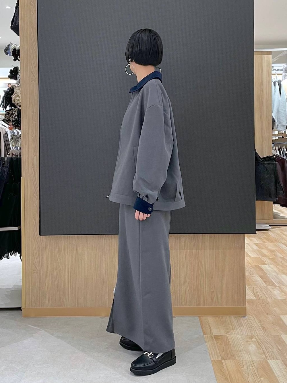 ブラック系のローファー、ブルー系のニット/セーター、シルバー系のショルダーバッグを着用したレディースの春コーディネートの4枚目の写真