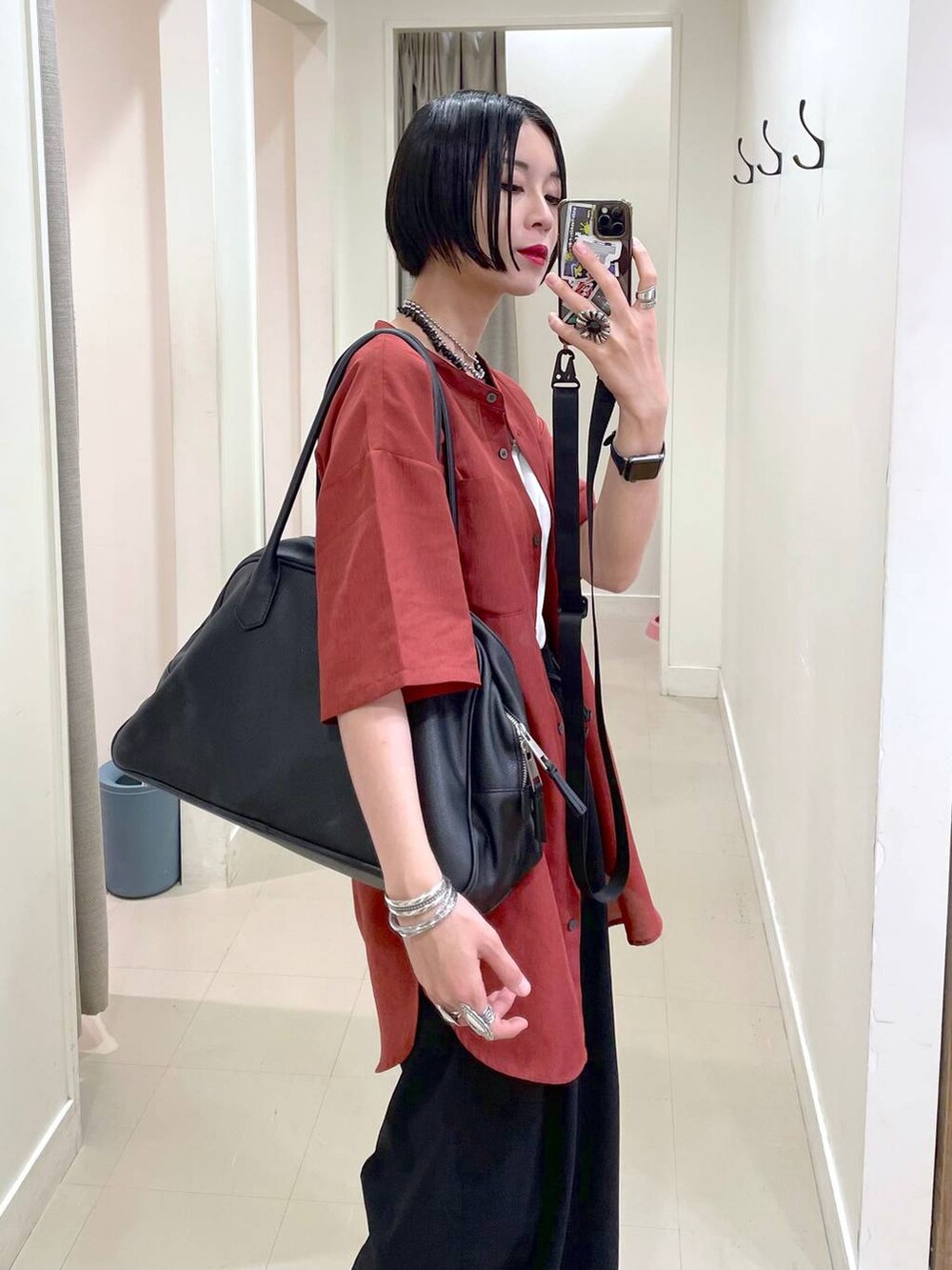 ブラック系のショルダーバッグ、ブラック系のその他パンツ、オレンジ系のシャツ/ブラウスを着用したレディースの夏コーディネートの7枚目の写真