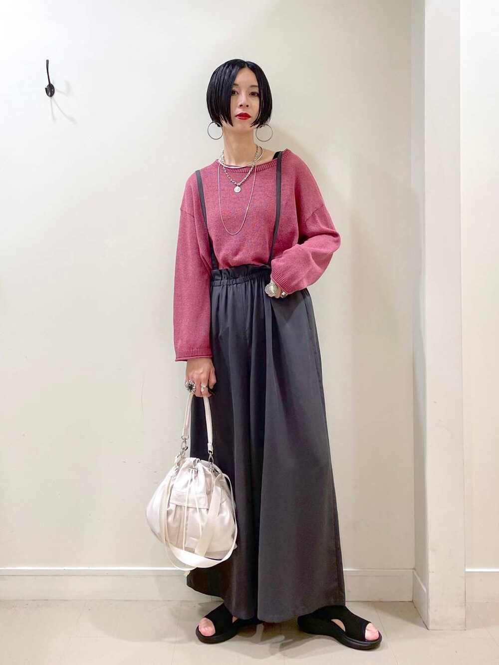 ホワイト系のショルダーバッグ、ブラック系のタンクトップ、ブラック系のサンダルを着用したレディースの秋コーディネートの8枚目の写真