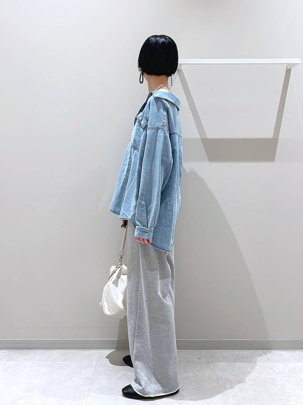 ブラック系のその他シューズ、ホワイト系のショルダーバッグ、グレー系のスウェットパンツを着用したレディースの春コーディネートの4枚目の写真