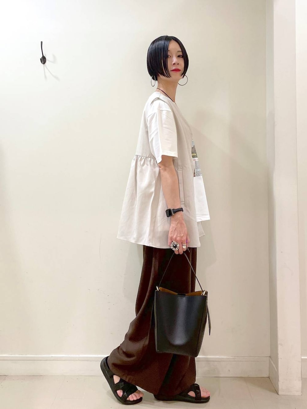 ブラック系のショルダーバッグ、ブラック系のサンダル、ブラウン系のその他パンツを着用したレディースの夏コーディネートの2枚目の写真