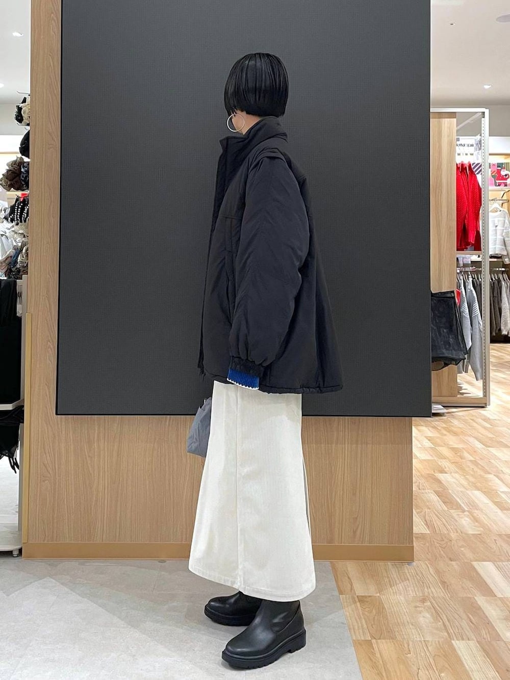 グレー系のトートバッグ、ブラック系のブルゾン、グレー系のスカートを着用したレディースの冬コーディネートの5枚目の写真