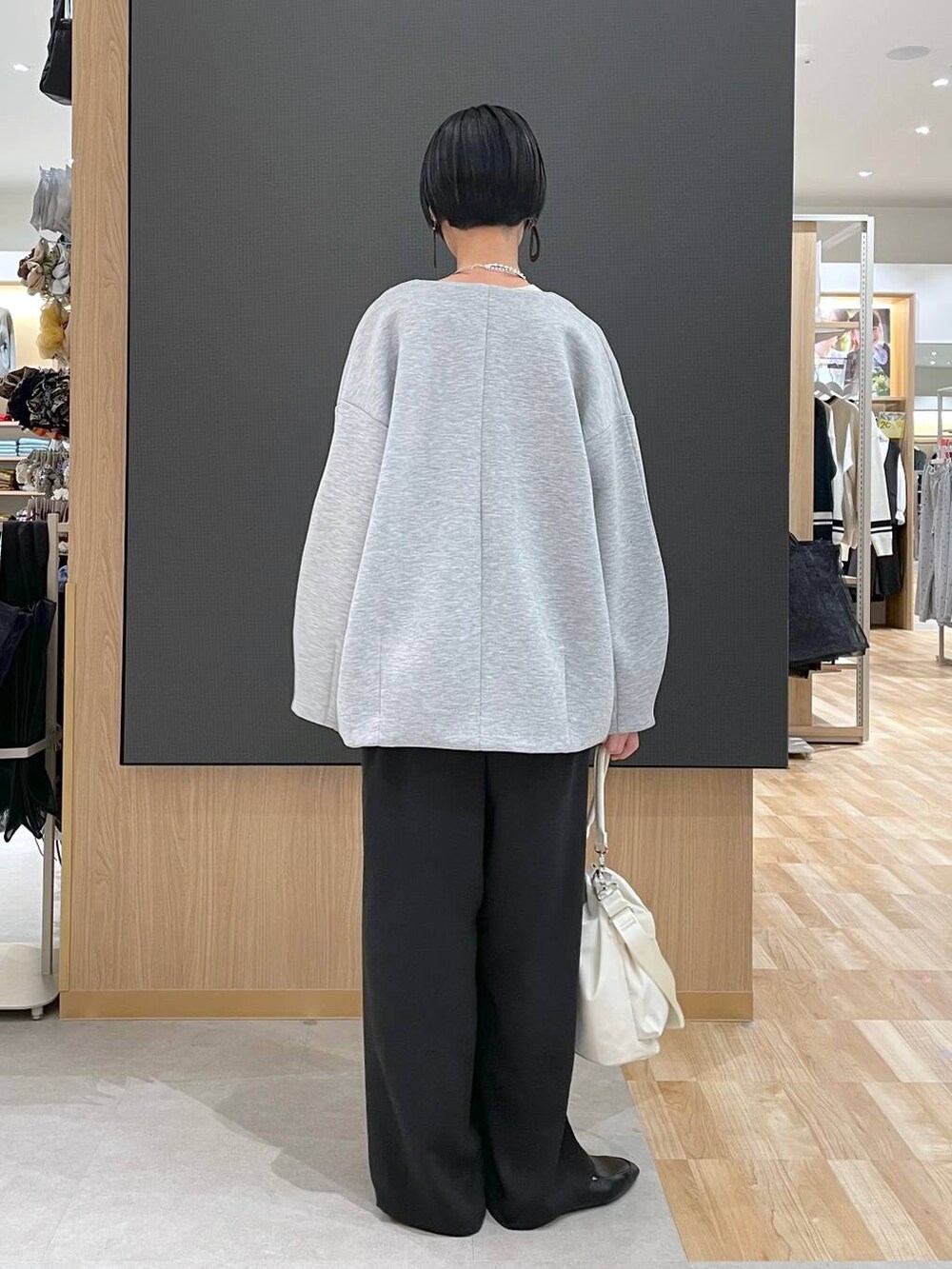 ブラック系のその他シューズ、ホワイト系のショルダーバッグ、グレー系のブルゾンを着用したレディースの春コーディネートの3枚目の写真