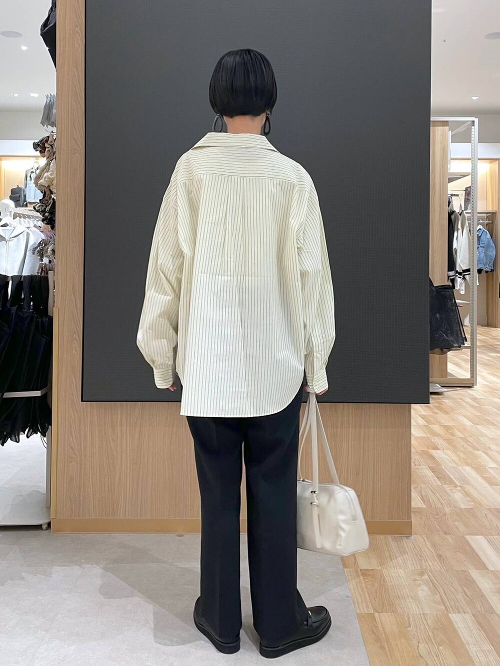 ブラック系のローファー、ブラック系のその他パンツ、ベージュ系のショルダーバッグを着用したレディースの春コーディネートの4枚目の写真