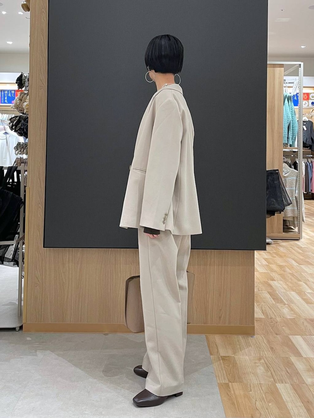 ブラウン系のローファー、ブラウン系のニット/セーター、ベージュ系のトートバッグを着用したレディースの冬コーディネートの4枚目の写真