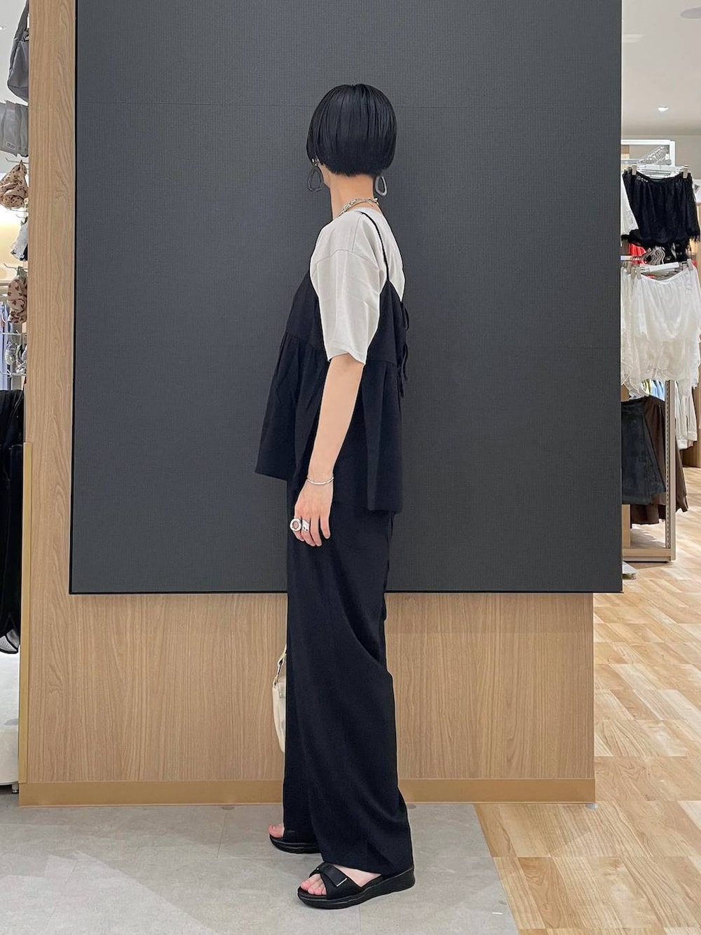 ブラック系のその他パンツ、ベージュ系のTシャツ/カットソー、ブラック系のサンダルを着用したレディースの夏コーディネートの4枚目の写真