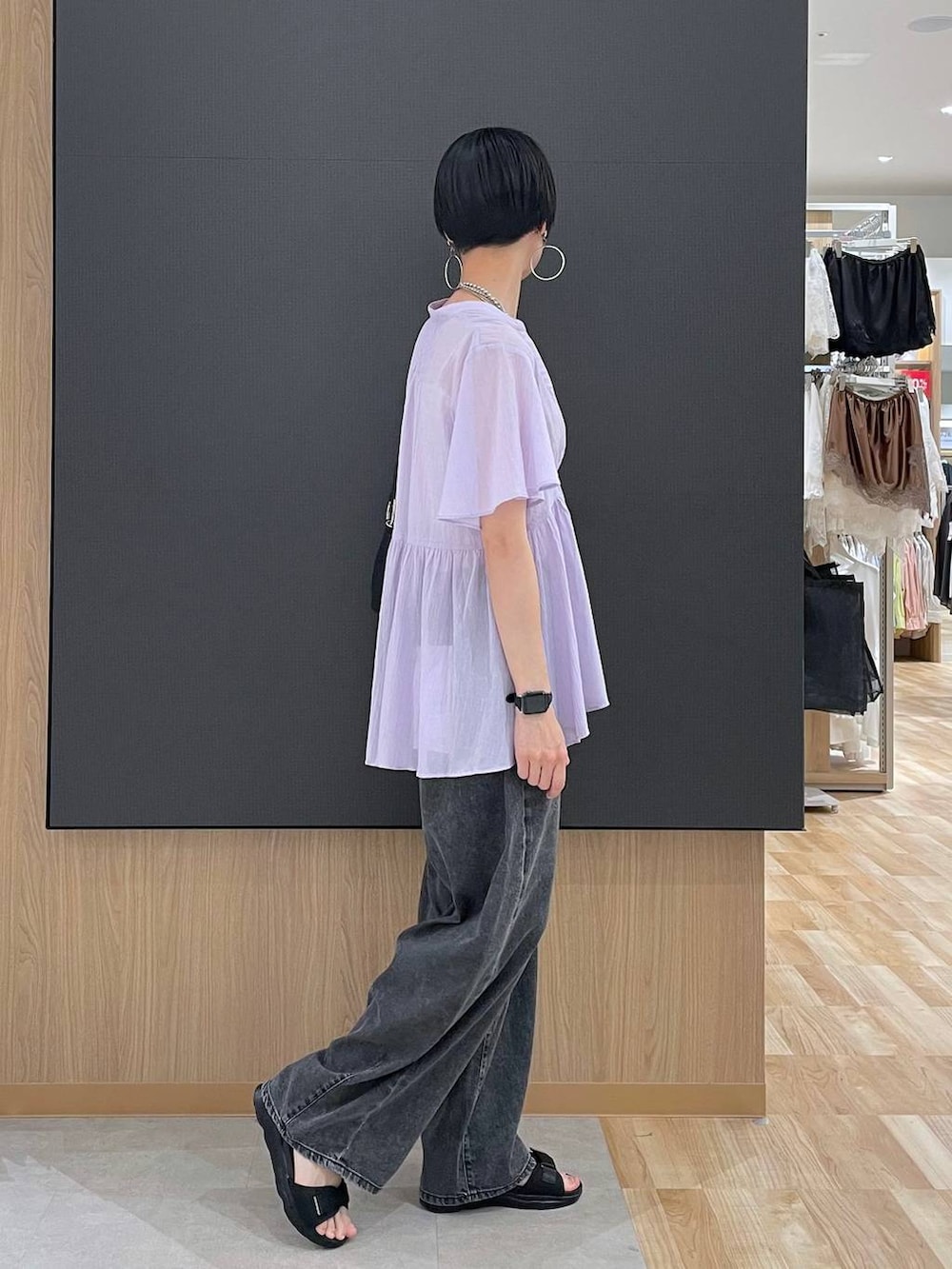 ホワイト系のキャミソール、ブラック系のデニムパンツ、ブラック系のサンダルを着用したレディースの夏コーディネートの3枚目の写真