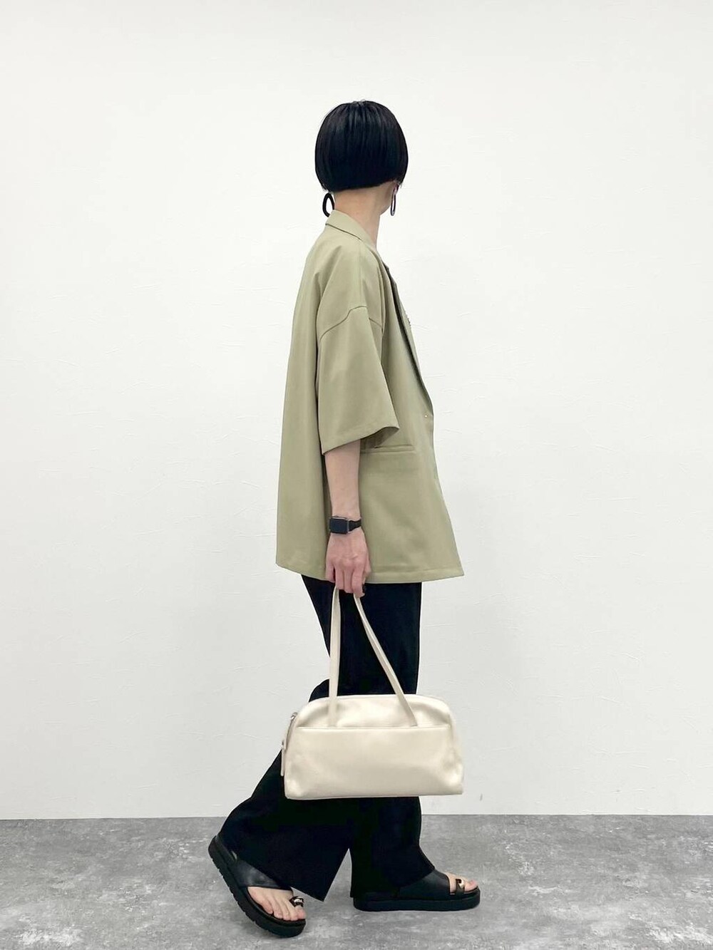 ブラック系のその他パンツ、ホワイト系のTシャツ/カットソー、ベージュ系のショルダーバッグを着用したレディースの春コーディネートの2枚目の写真