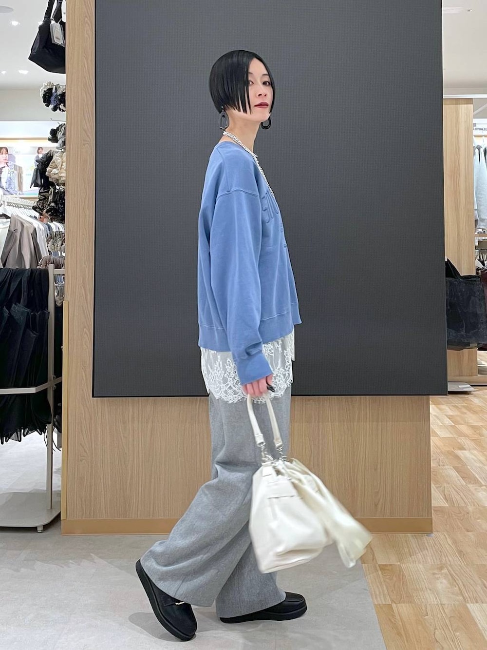 ブラック系のローファー、ホワイト系のショルダーバッグ、グレー系のその他パンツを着用したレディースの冬コーディネートの2枚目の写真