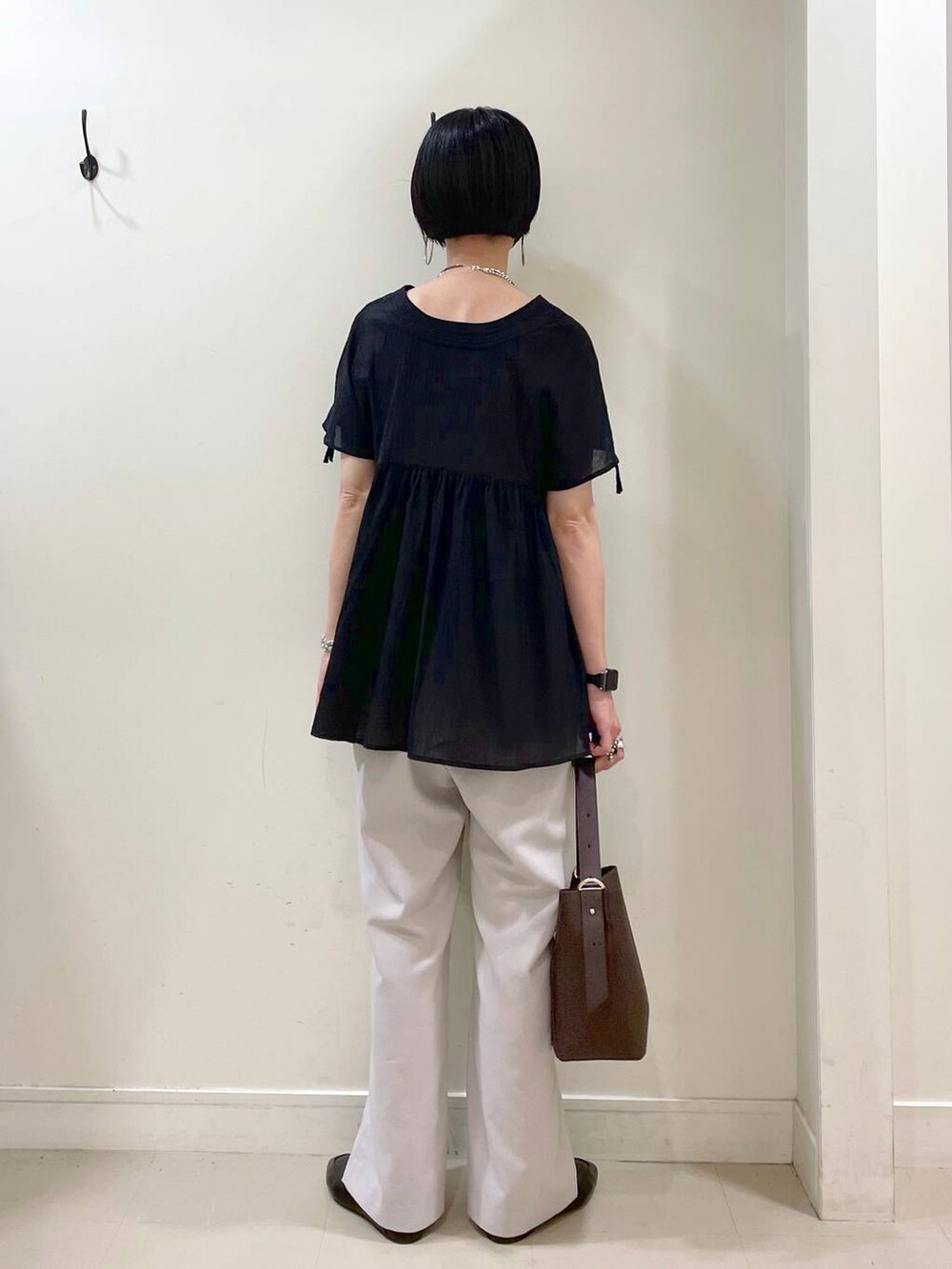 ブラック系のその他シューズ、ブラウン系のショルダーバッグ、ベージュ系のその他パンツを着用したレディースの夏コーディネートの3枚目の写真