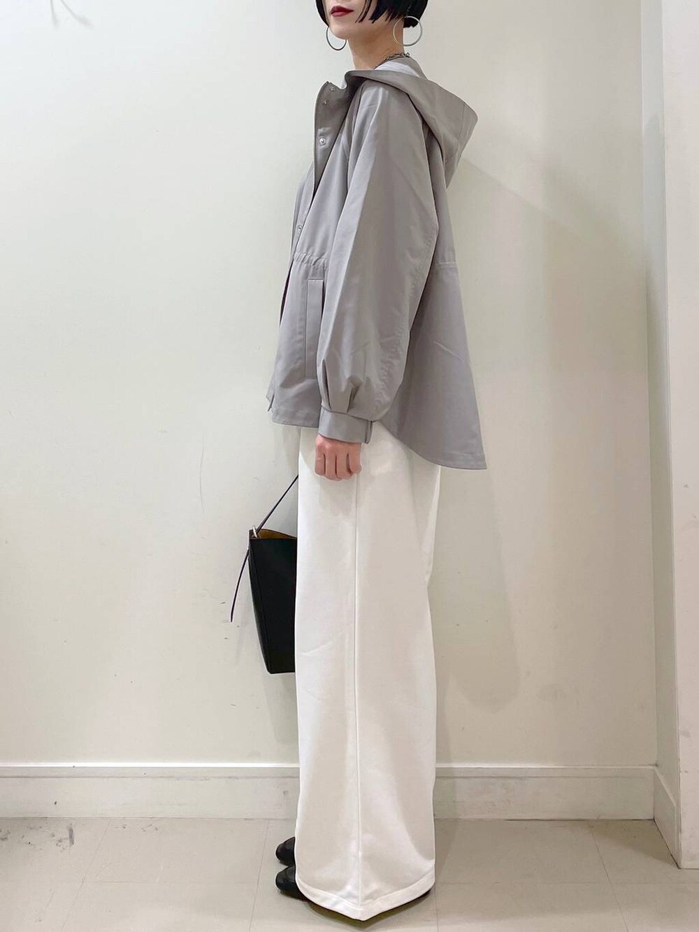 ブラック系のその他シューズ、グリーン系のマウンテンパーカー、ブラック系のショルダーバッグを着用したレディースの春コーディネートの5枚目の写真