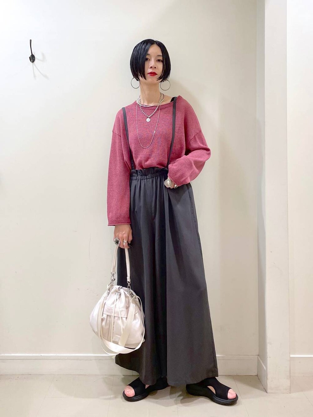 ホワイト系のショルダーバッグ、ブラック系のタンクトップ、ブラック系のサンダルを着用したレディースの秋コーディネートの6枚目の写真