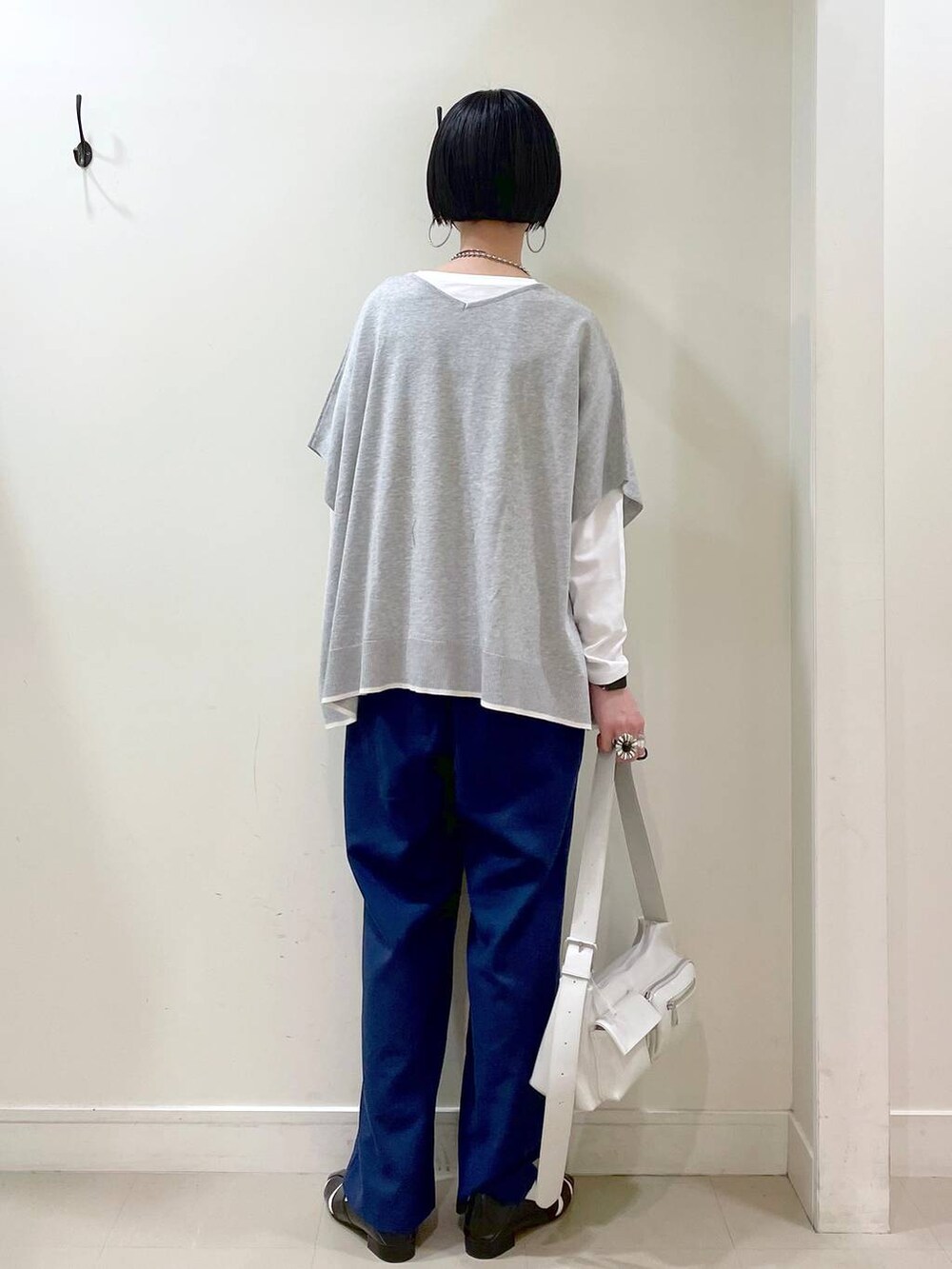 ホワイト系のショルダーバッグ、ホワイト系のTシャツ/カットソー、グレー系のニット/セーターを着用したレディースの春コーディネートの4枚目の写真