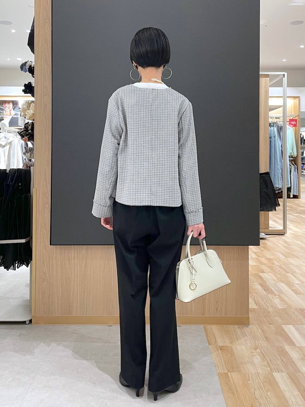 ホワイト系のショルダーバッグ、ブラック系のパンプス、ブラック系のスラックスを着用したレディースの冬コーディネートの4枚目の写真