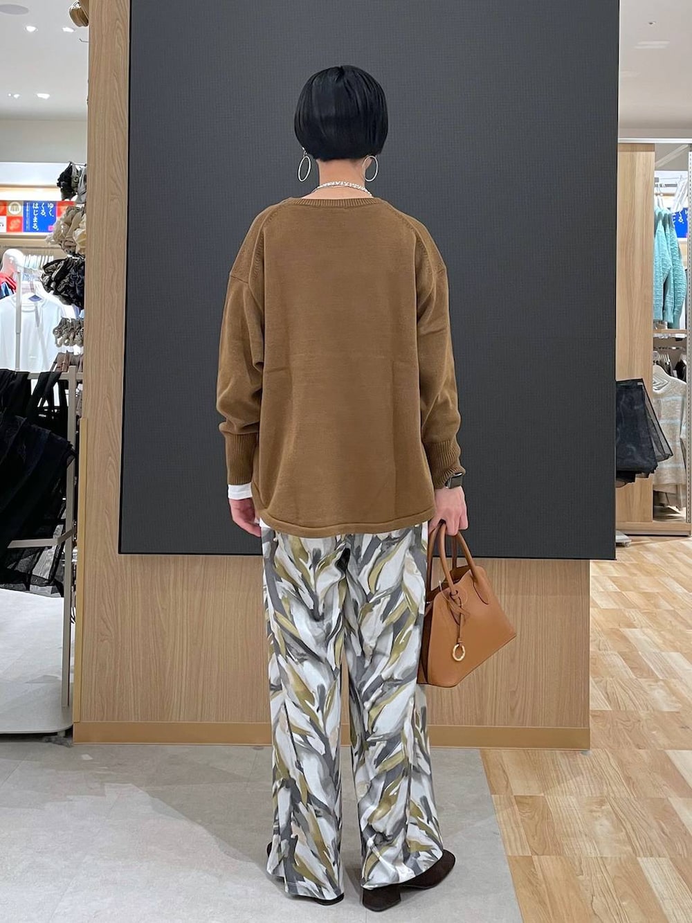 ブラウン系のショルダーバッグ、ブラウン系のニット/セーター、ブラウン系のブーツを着用したレディースの冬コーディネートの8枚目の写真