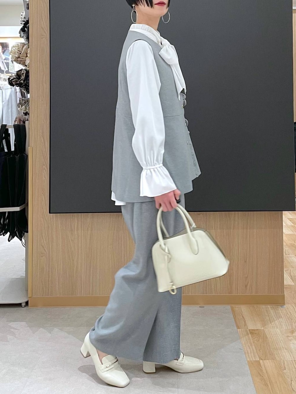 ベージュ系のローファー、ホワイト系のショルダーバッグ、グレー系のその他パンツを着用したレディースの冬コーディネートの2枚目の写真