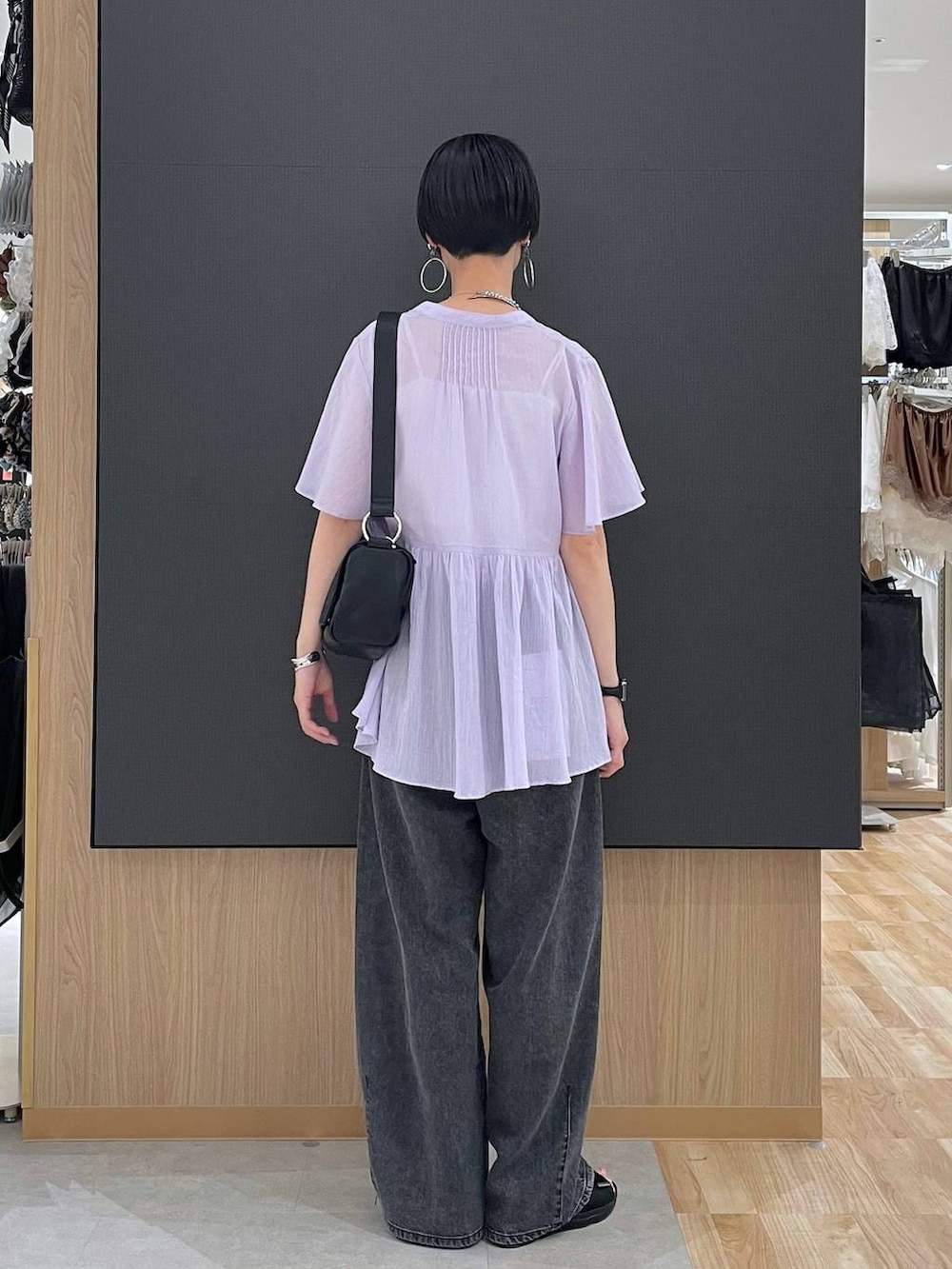 ホワイト系のキャミソール、ブラック系のデニムパンツ、ブラック系のサンダルを着用したレディースの夏コーディネートの4枚目の写真