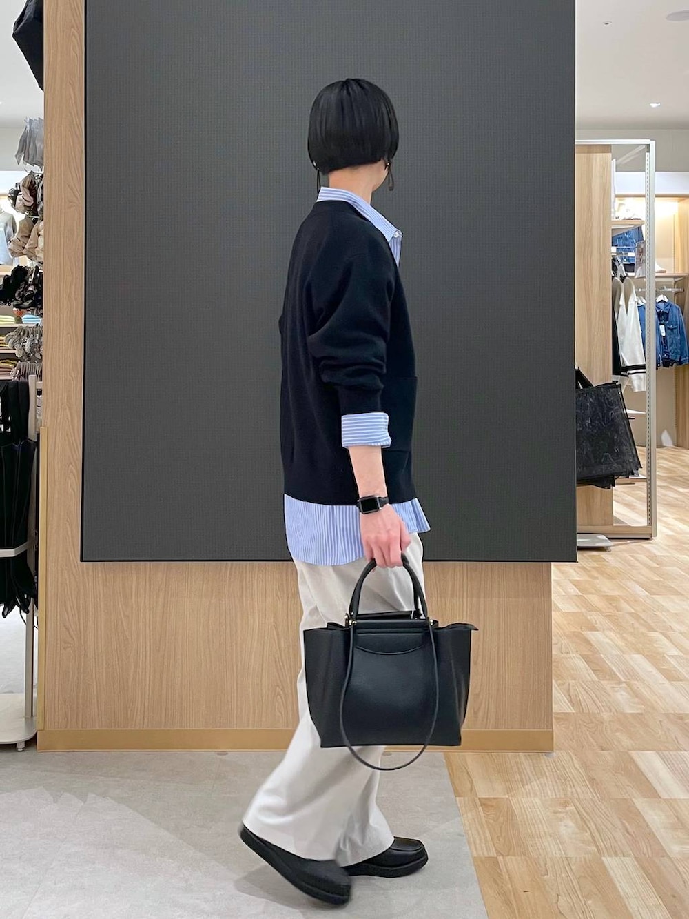 ブラック系のローファー、ブラック系のトートバッグ、ブルー系のシャツ/ブラウスを着用したレディースの春コーディネートの2枚目の写真