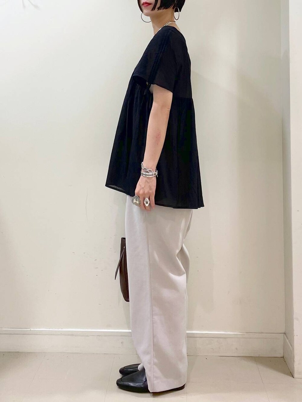 ブラック系のその他シューズ、ブラウン系のショルダーバッグ、ベージュ系のその他パンツを着用したレディースの夏コーディネートの4枚目の写真