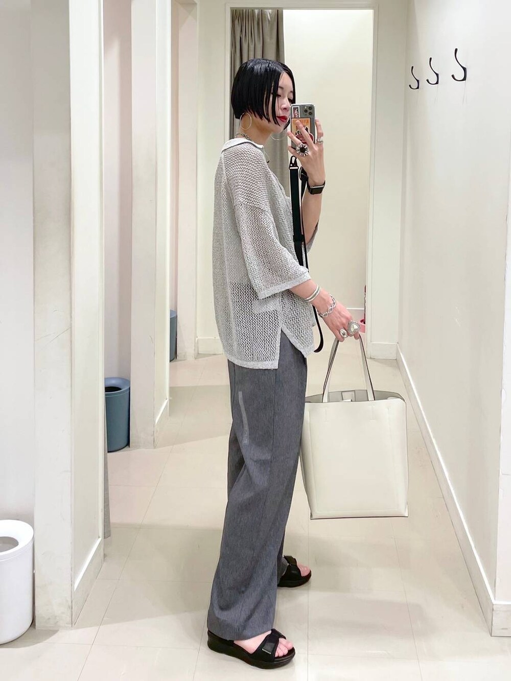 ホワイト系のトートバッグ、ホワイト系のキャミソール、ブラック系のサンダルを着用したレディースの夏コーディネートの2枚目の写真